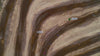 Overhead view of a motocross track with riders racing dirt bikes on it.
